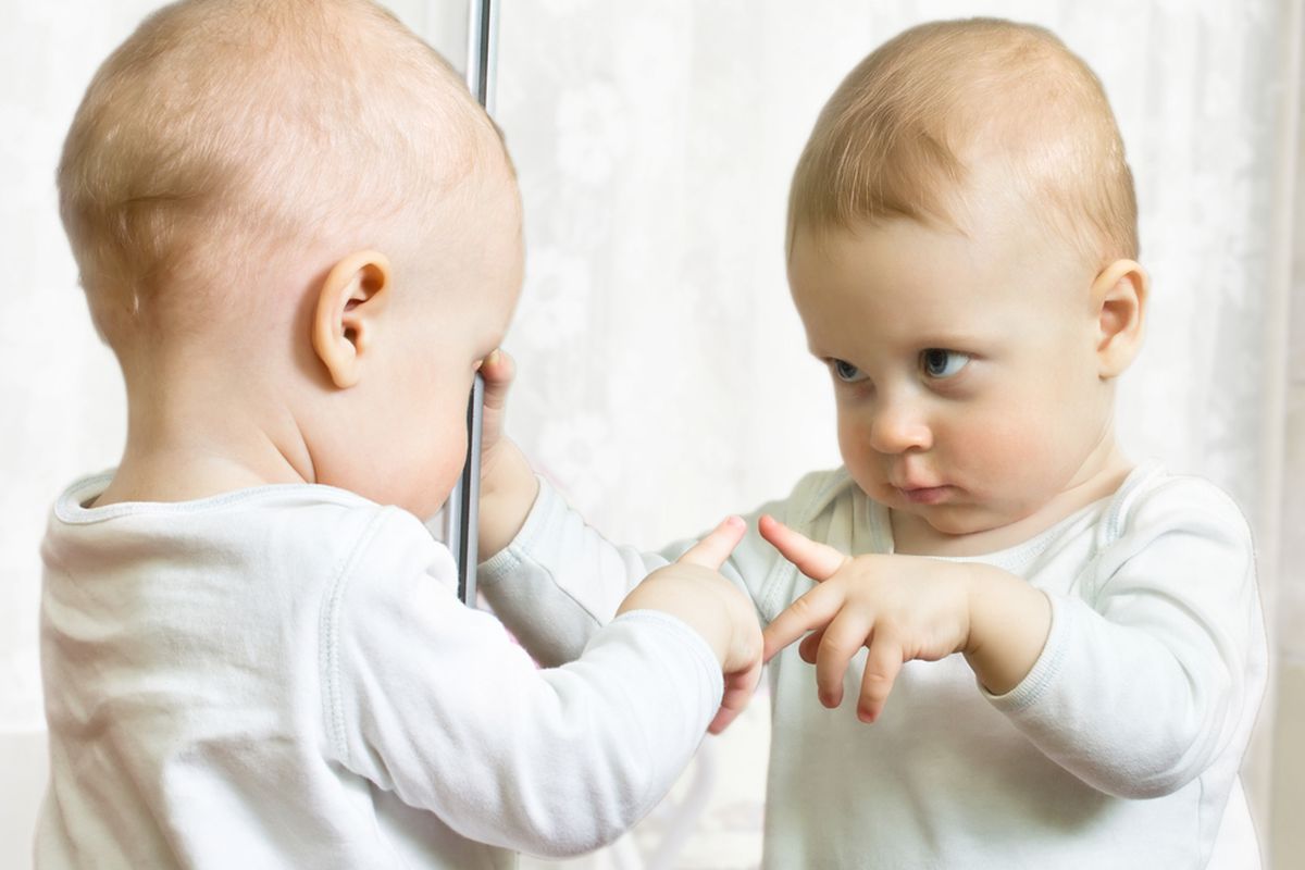 Baby schaut in den Spiegel